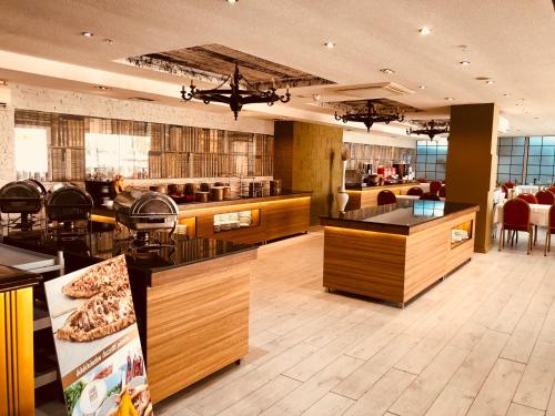 a restaurant with tables and chairs and a pizzaastery at Grand Amisos Hotel in Samsun