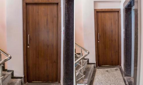 a pair of wooden doors in a building with stairs at Treebo Trend Naunidh Suites in Pune