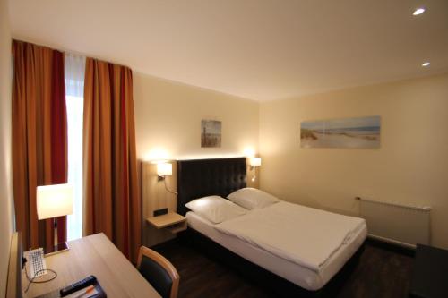 Habitación de hotel con cama y escritorio en Hotel Sonderfeld en Grevenbroich