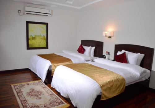 2 łóżka w pokoju hotelowym z białą pościelą w obiekcie Hotel One Sukkur w Kalar Goth