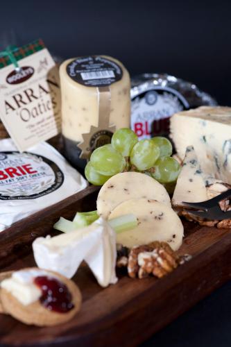 a wooden plate with cheese and grapes and nuts at The Douglas Hotel in Brodick