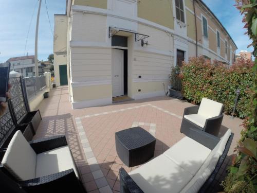 a patio with white benches and a building at Doma 4.2 in Riccione