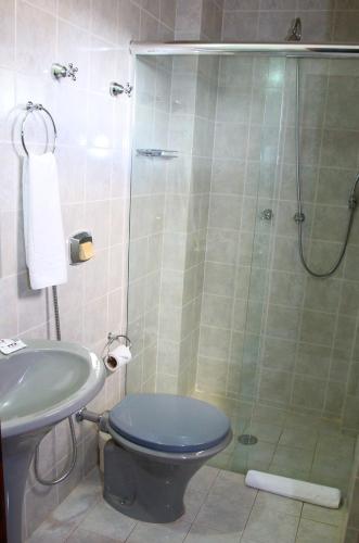 a bathroom with a shower with a toilet and a sink at Mabruk Barretos Apart Hotel in Barretos