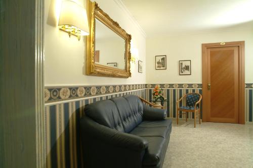a living room with a couch and a mirror at Hotel Teti in Rome