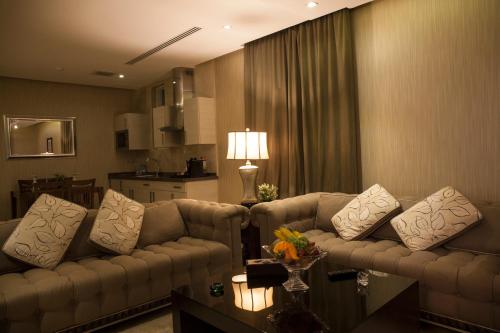 a living room with couches and a table with a lamp at Aswar Hotel Suites in Riyadh