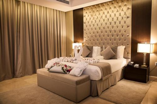 a hotel room with a large bed with white pillows at Aswar Hotel Suites in Riyadh