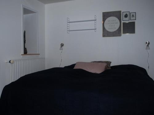a bedroom with a bed with a black blanket at Adventure Park Apartments in Ringkøbing