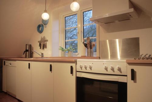 a kitchen with a white stove and a window at Adventure Park Apartments in Ringkøbing