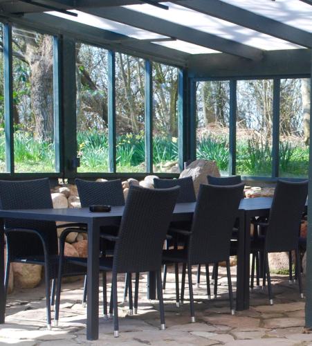 a dining room with tables and chairs and windows at Adventure Park Apartments in Ringkøbing