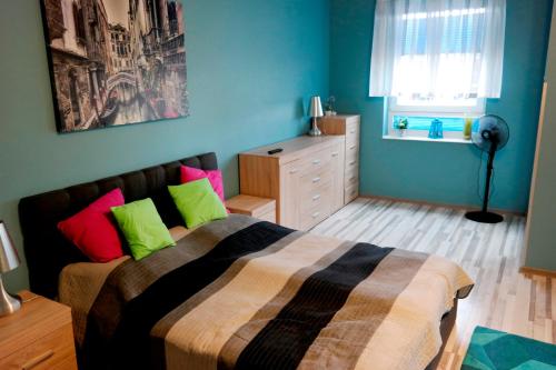 科沃布热格Polonia Apartamenty的一间卧室配有带绿色和粉红色枕头的床