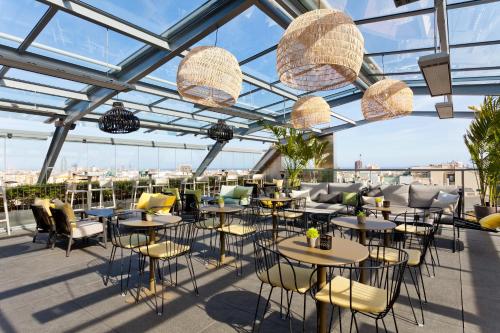 a restaurant with tables and chairs and glass ceilings at Hotel Royal Passeig de Gracia in Barcelona