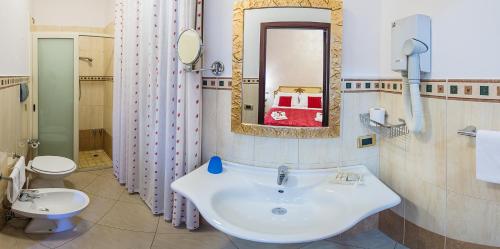 a bathroom with a sink and a toilet and a mirror at Garibaldi Relais in Sciacca