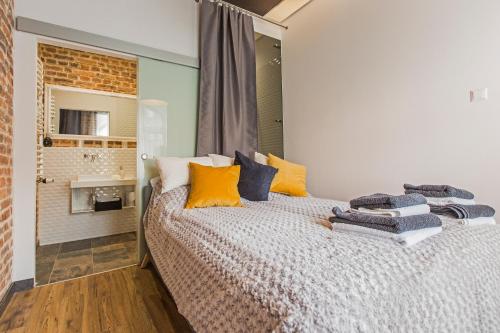 sypialnia z łóżkiem z niebieskimi i żółtymi poduszkami w obiekcie Zillmann Apartment w mieście Katowice