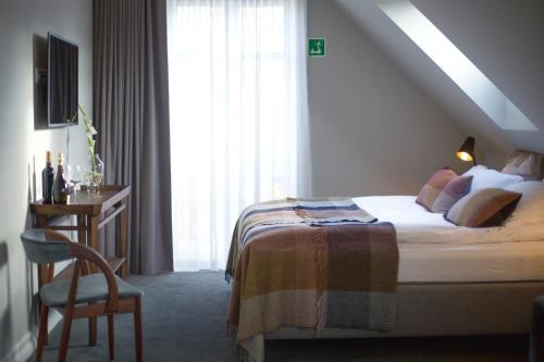 a bedroom with a bed and a desk and a window at Reykjavik Residence Apartment Hotel in Reykjavík