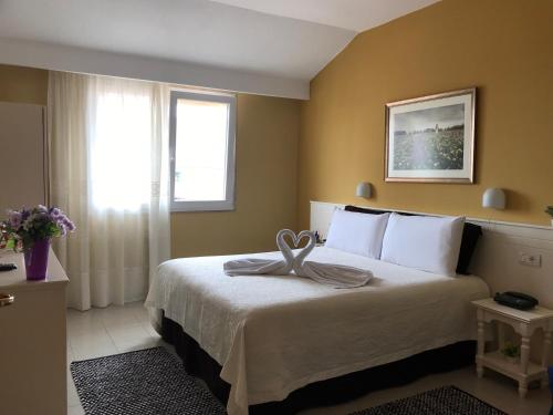 Una habitación de hotel con una cama con una toalla. en Hotel Nais, en Durrës