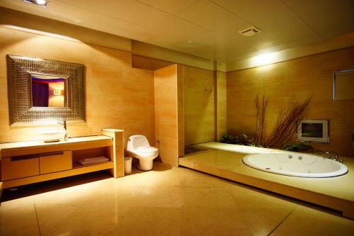 a bathroom with a tub and a toilet and a sink at Water City Motel in Daya