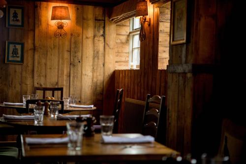 a restaurant with wooden tables and chairs and a window at The Hawk Inn in Andover