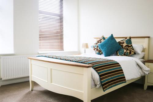 a bedroom with a white bed with blue pillows at Cill Aodain Court Hotel in Kiltimagh