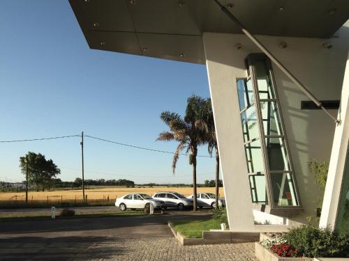 a building with cars parked in a parking lot at Hotel Camberland in Pilar