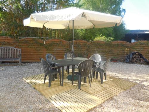 a black table with chairs and an umbrella at les gîtes de l'argenterie à 15km du zoo de Beauval classés 4 étoiles in Fontguenand