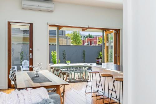 a kitchen and living room with a table and chairs at Central Bendigo Cottage, walk to everywhere!! in Bendigo