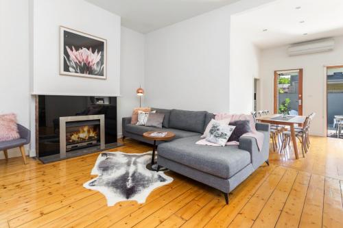 a living room with a couch and a fireplace at Central Bendigo Cottage, walk to everywhere!! in Bendigo