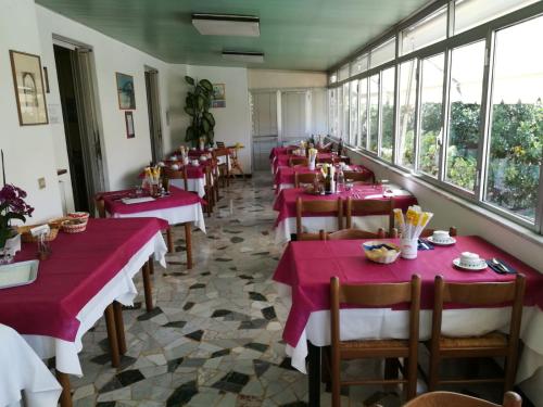 a row of tables in a restaurant with red tablecloths at Albergo Calcagno in Borgio Verezzi
