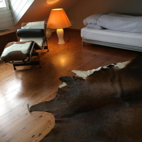 a bedroom with a broke floor in a room with a bed and a chair at Ruheges Zimmer, 100 m zum See, Strandbad in Bottighofen