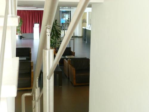 a lobby with a staircase with chairs and a couch at Hotel Monte Sarago in Ostuni