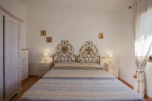 un grande letto in una camera da letto con due comodini di Belvedere Suites - Klodge a Olbia