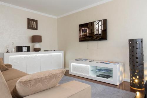a living room with a couch and a tv on the wall at The Queen Luxury Apartments - Villa Vinicia in Luxembourg