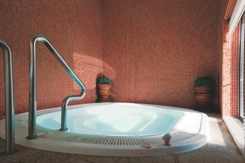 a jacuzzi tub in a red brick bathroom at Vila Gale Santa Cruz in Santa Cruz