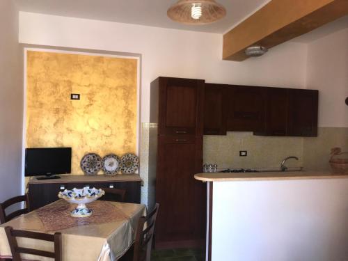 a kitchen with a table with a bowl of flowers on it at Casa Terme in Sciacca