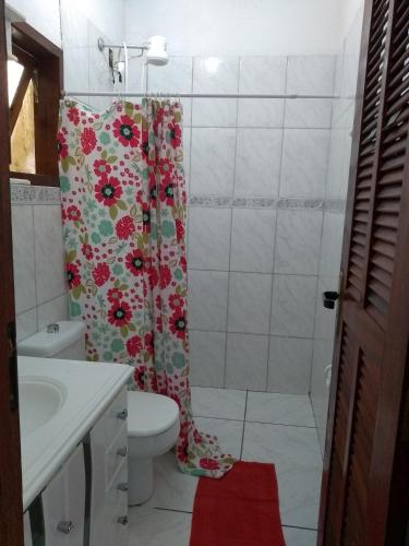 a bathroom with a shower curtain and a toilet at Pousada Popeye in Praia de Araçatiba