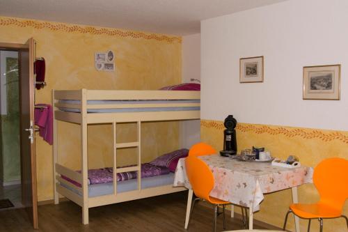 ルストにあるGästehaus Europaのベッドルーム1室(二段ベッド1組、テーブル、椅子付)