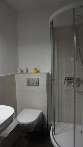 a bathroom with a toilet and a glass shower at Kiteblick in Büsum