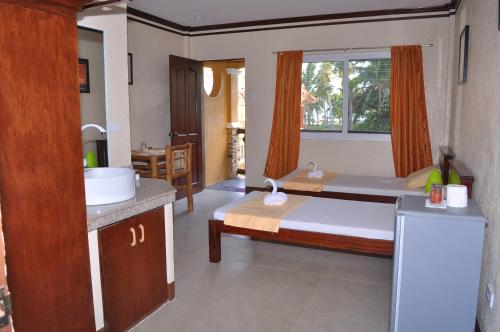 una camera con letto e una cucina con finestra di SLAM'S Garden Dive Resort a Isola di Malapascua