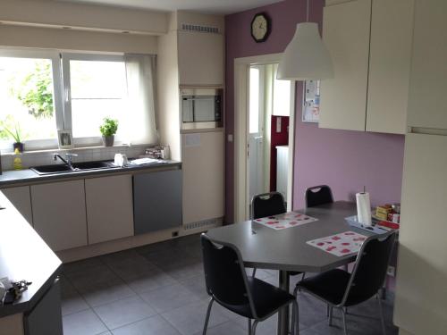 una cucina con tavolo, sedie e lavandino di didi logement a Westerlo