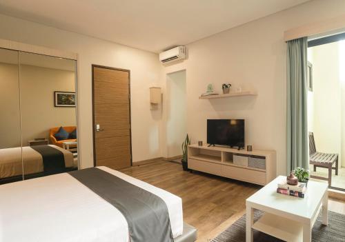 a bedroom with a bed and a tv and a couch at Treehouse Suites - Boutique Serviced Apartment in Jakarta