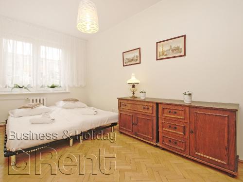 グダニスクにあるApartament Beniowskiegoのベッドルーム1室(ベッド1台、木製ドレッサー付)