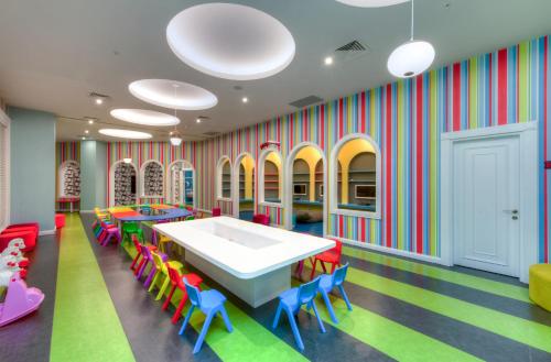 a colorful classroom with a table and chairs at Granada Luxury Belek - Family Kids Concept in Belek