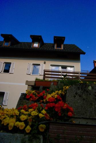 a building with a bunch of flowers in front of it at Apartmaji Pri Kokolu in Bled