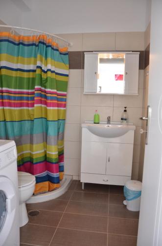 KamáriaにあるHelona Housesのバスルーム(カラフルなシャワーカーテン、シンク付)