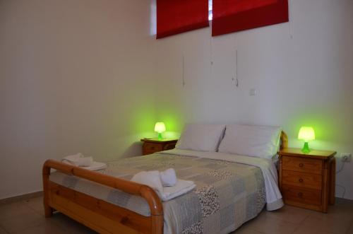 KamáriaにあるHelona Housesのベッドルーム1室(ベッド1台付)、2泊分のスタンド(ランプ付)