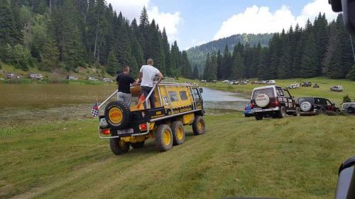 two men are standing on the back of a truck at Motel Krstac in Mojkovac