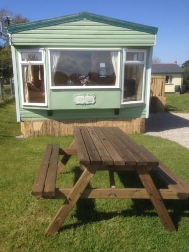 a picnic table in front of a tiny house at Luxury Mobile Home near Perranporth situated on a quiet farm in Truro