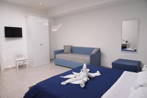 a bedroom with a large bed with a blue couch at B&b VICTORIA in Porto Cesareo