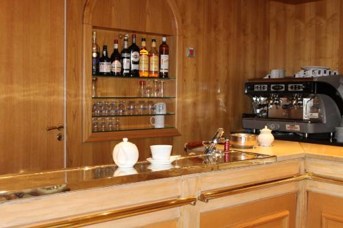 a kitchen with a counter with a sink and a microwave at Hôtel Sainte Marie in Lourdes