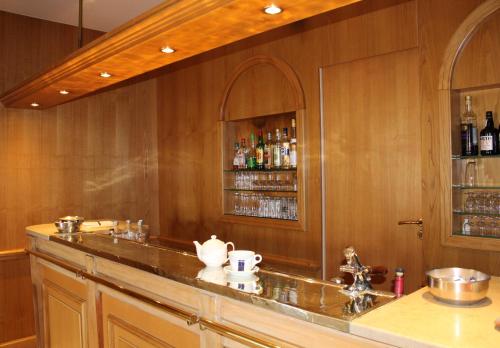 a kitchen with a bar with alcohol bottles at Hôtel Sainte Marie in Lourdes