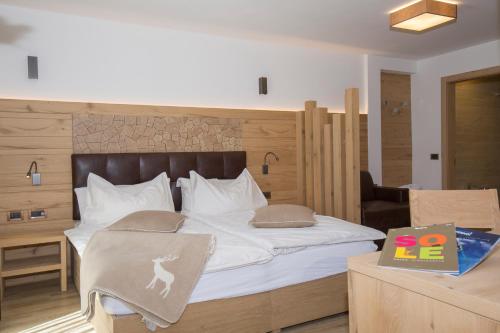 a bedroom with a bed and a desk with a laptop at La Torretta in Passo del Tonale
